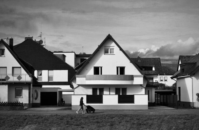 Moderne Eltern mit Baby unterwegs im Park mit praktischem Kinderwagen