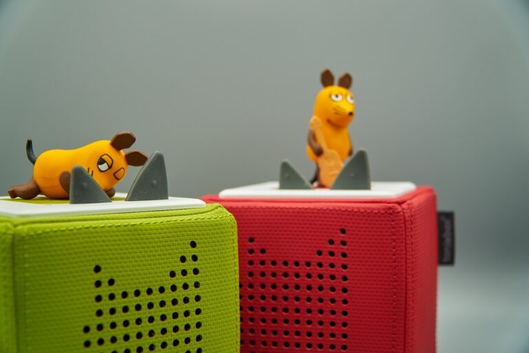 Wie die Toniebox spielerisch die Entwicklung von Kindern fördert Kind spielt begeistert mit der bunten Toniebox und interaktiven Figuren