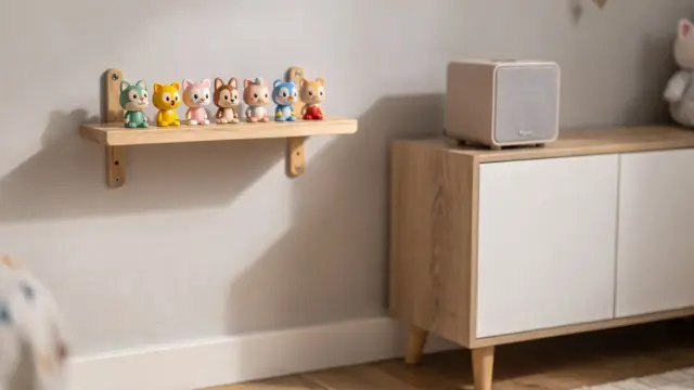 Wandmontiertes Tonie-Regal mit aufgereihten Figuren im Kinderzimmer neben einer Toniebox